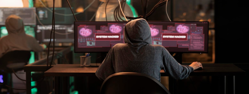 Un hacker trabaja con dos computadoras.